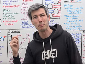 Engineering Explained stands in front of a whiteboard with lots of calculations written on the board